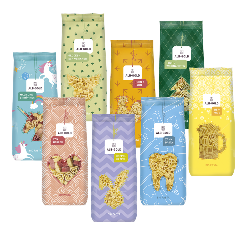 Acht bunte ALB-GOLD Nudelpäckchen mit verschiedenen Formen und Themen wie Einhörner, Herzen, Hasen, Zähne und Bierkrug in Bio Qualität Acht bunte ALB-GOLD Nudelpäckchen mit verschiedenen Formen und Themen wie Einhörner, Herzen, Hasen, Zähne und Bierkrug in Bio Qualität
